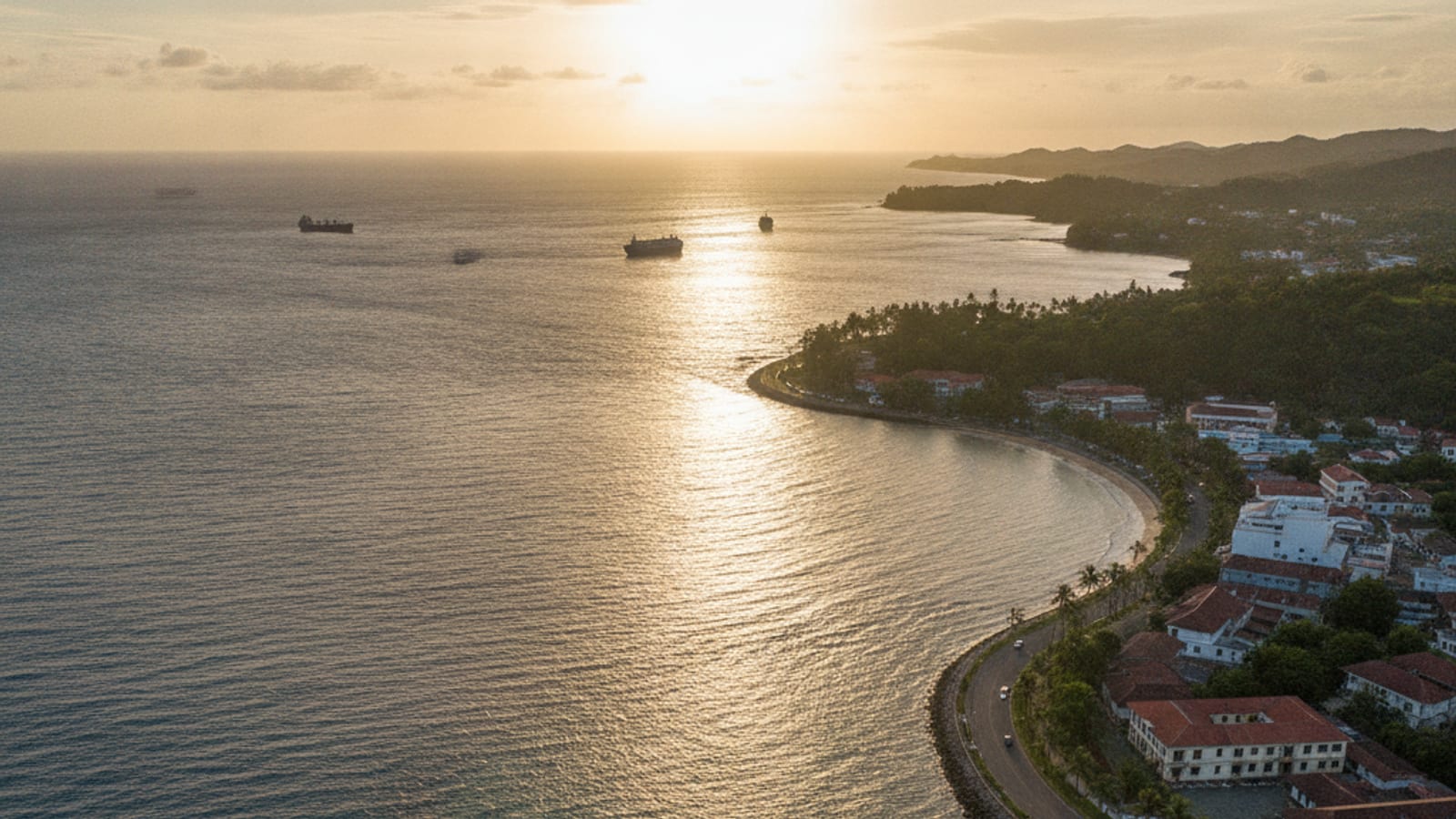 An aerial view of the Dili waterfront meeting the sea at golden hour