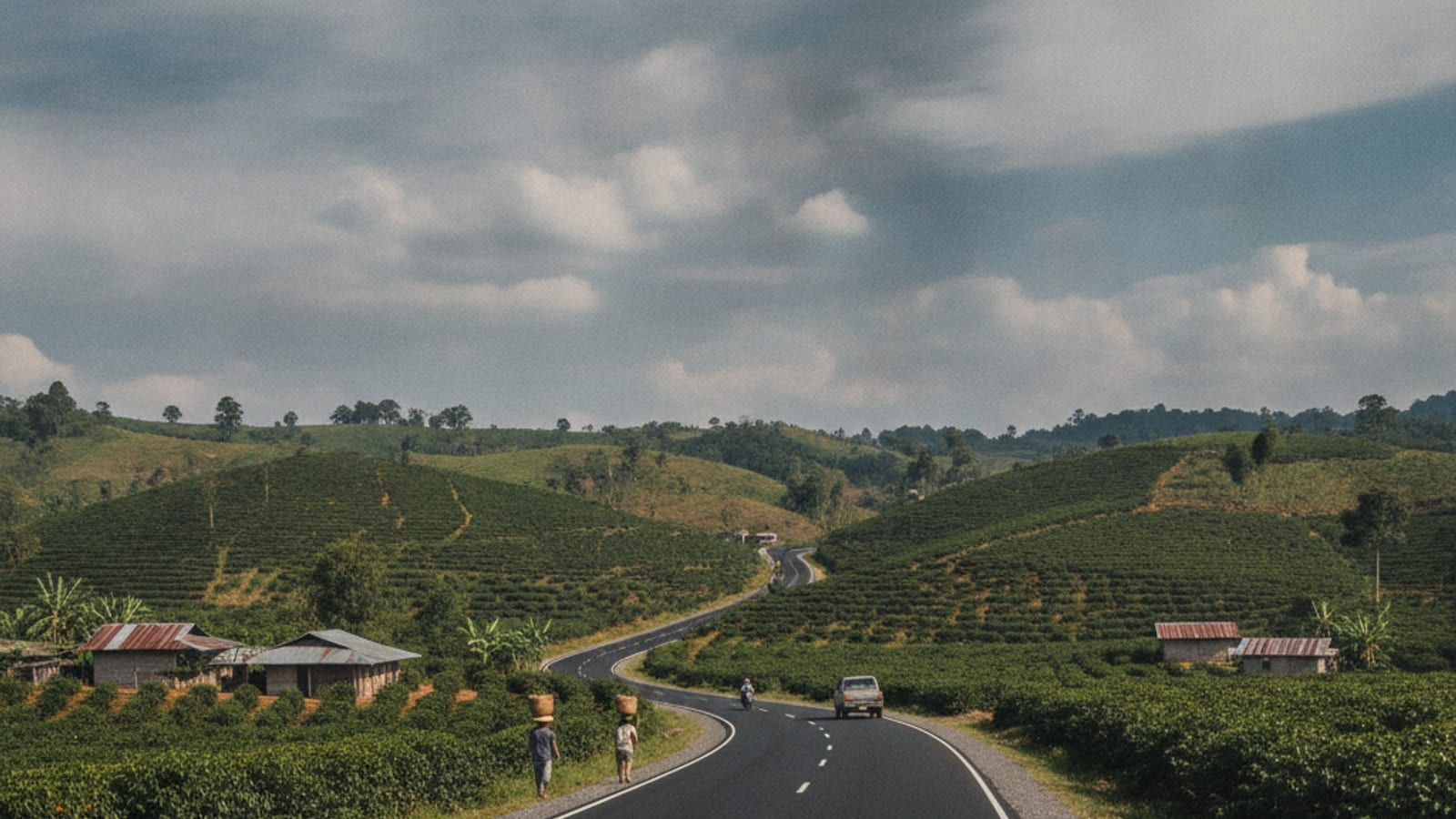 A newly rehabilitated road in Ermera, Timor-Leste, passing through lush green hills and agricultural land.