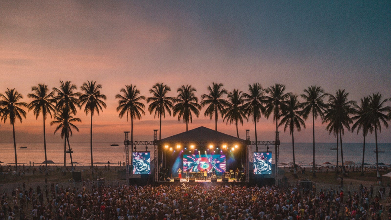 An outdoor music festival at Tasi-Tolu, Dili, with a stage and crowd.